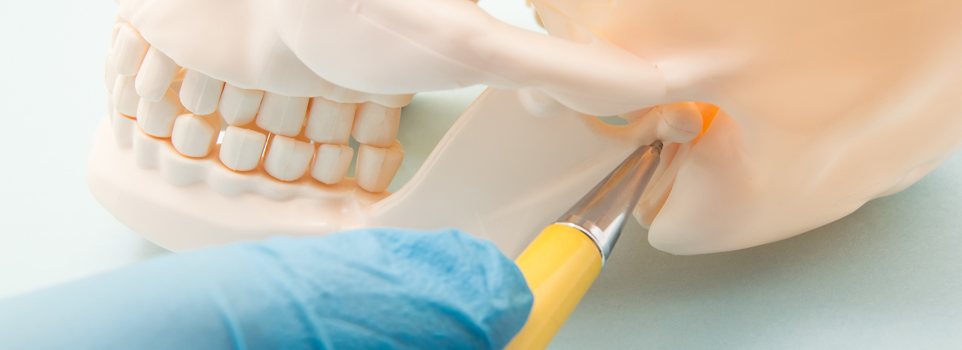 A dental implant being installed with a blue surgical tool in a clinical setting.